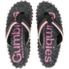 Gumbies France black and pink knit flip-flops with "#WorldWideWalkabout" text and white/pink striped straps.