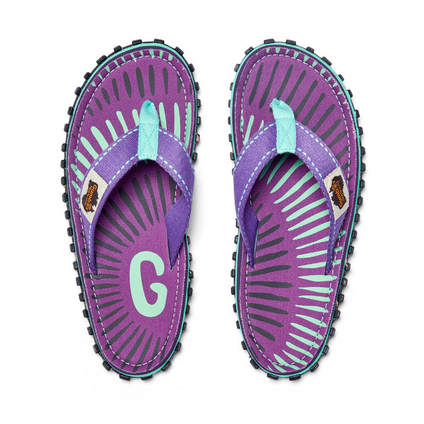 GUMBIES FRANCE Islander flip-flops with purple canvas, mint green and grey sunburst pattern, and mint green straps.