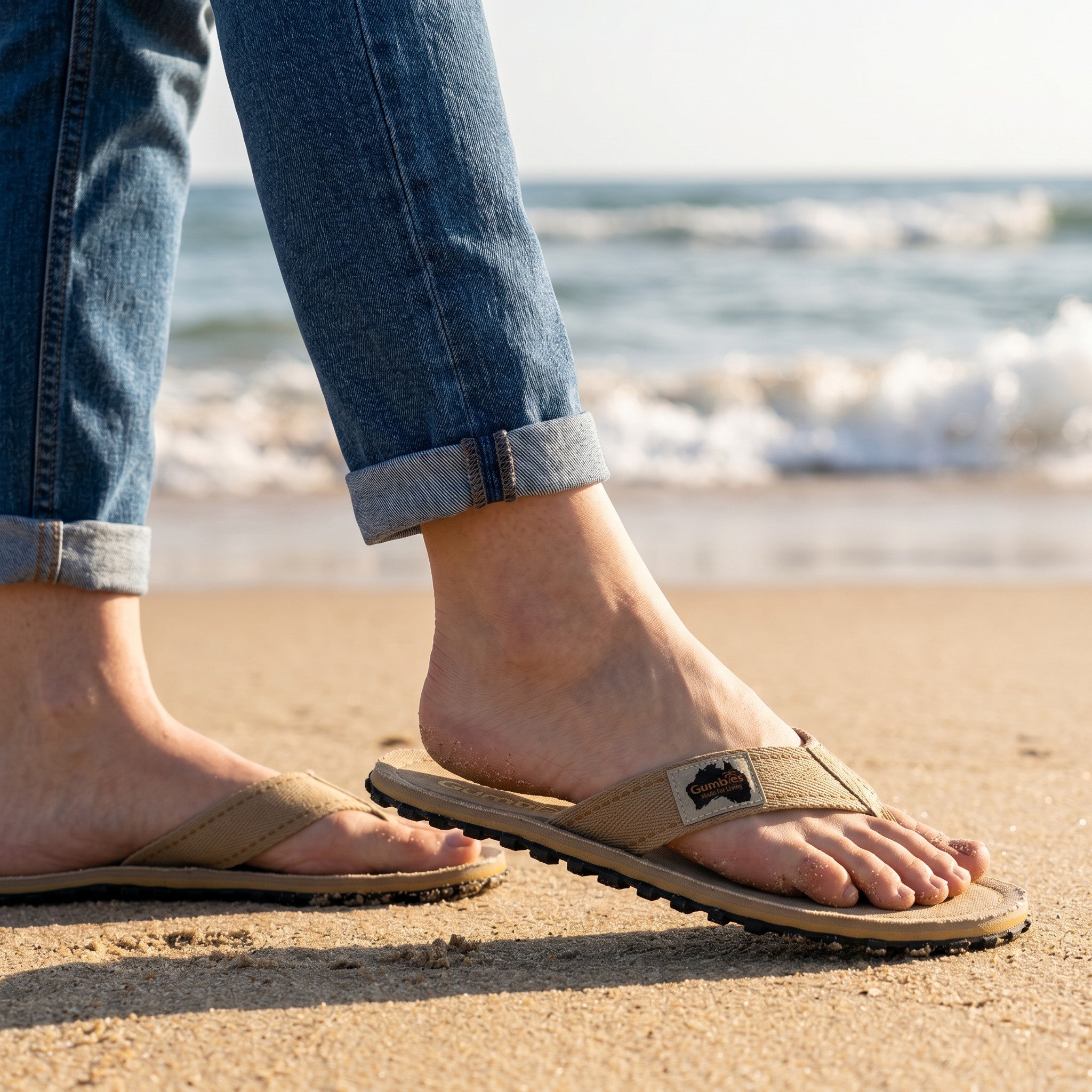 Gumbies FRANCE tan canvas flip-flops with a textured black rubber sole and a small woven label featuring the Gumbies logo and Australia.