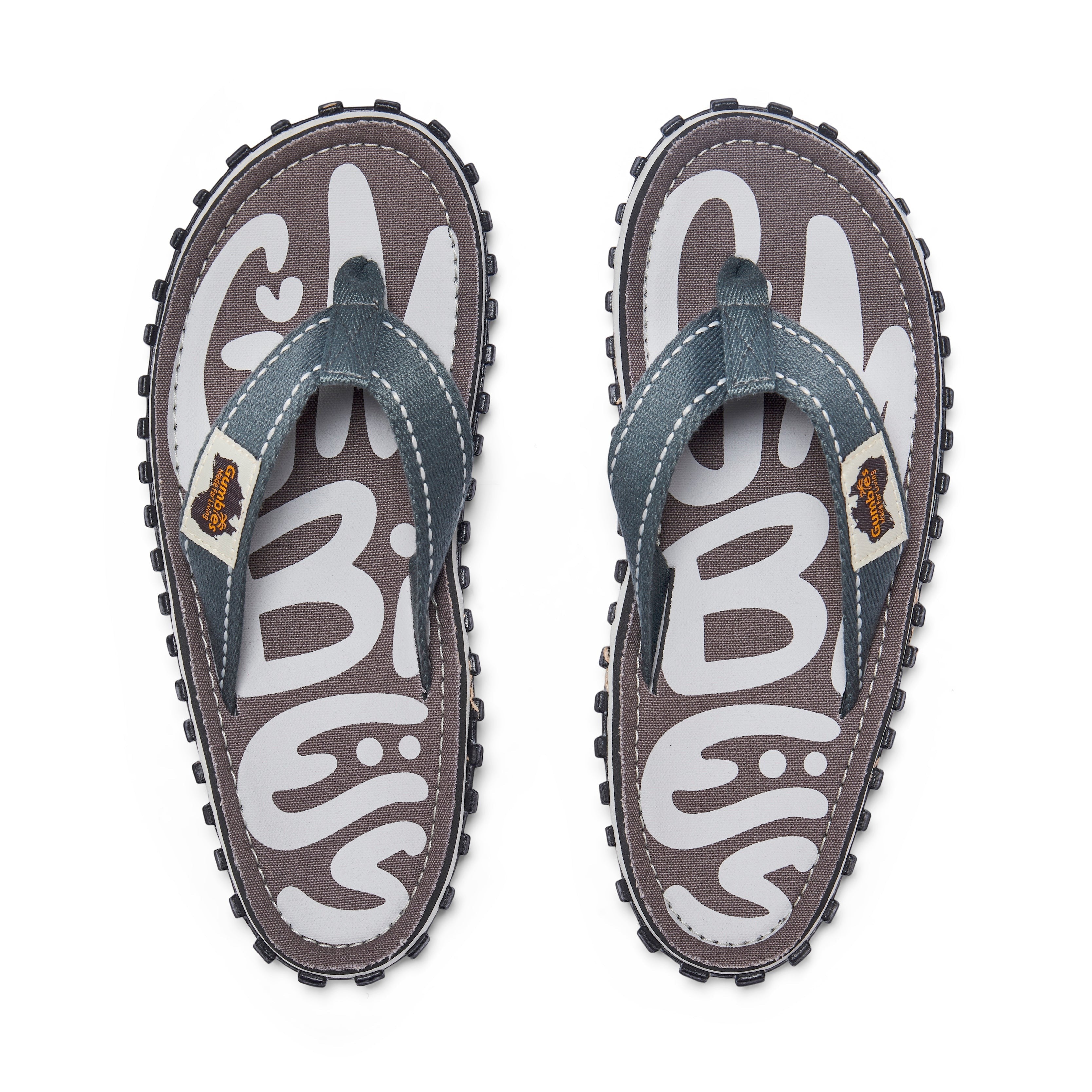 GUMBIES FRANCE Islander Urban Grey flip-flops with white GUMBIES logo on grey canvas, grey denim straps, and black rubber sole.