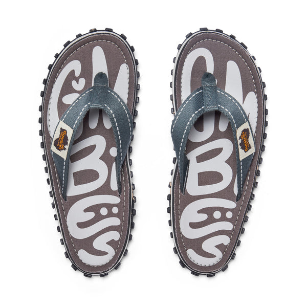 GUMBIES FRANCE Islander Urban Grey flip-flops with white GUMBIES logo on grey canvas, grey denim straps, and black rubber sole.